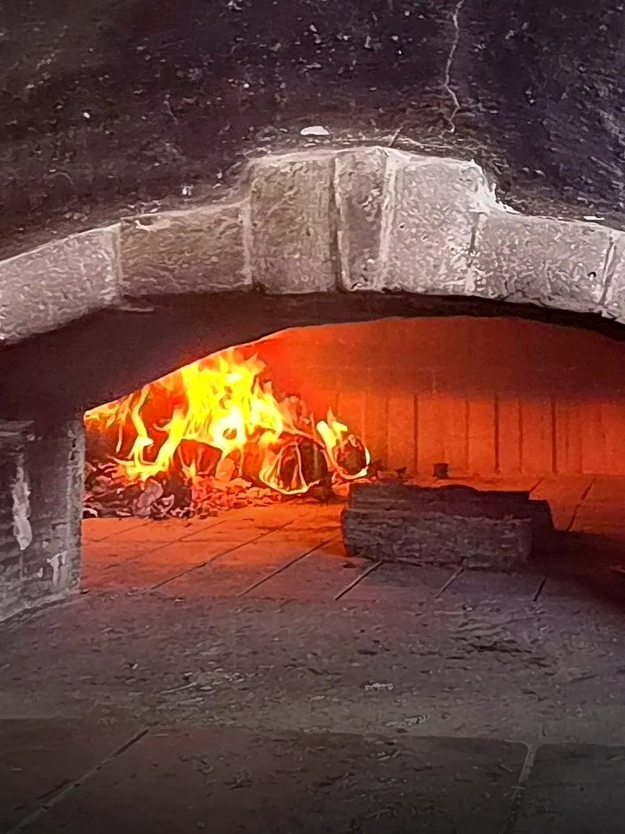 Fire burning inside Tano’s wood-fired oven